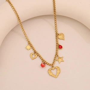 Dettaglio della collana a catena dorata con perle rosse e ciondoli a cuore