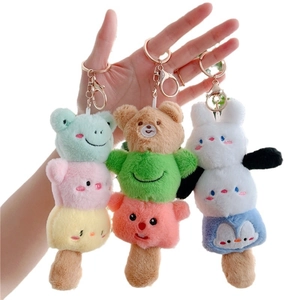 Cute stacked animal plush keychains with frog and bear designs held in hand