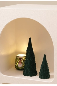 Close-up of two dark green flocked ceramic Christmas trees with soft velvet texture