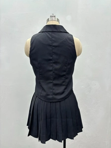 Vue arrière d'un ensemble deux pièces avec gilet noir sans manches et mini-jupe plissée
