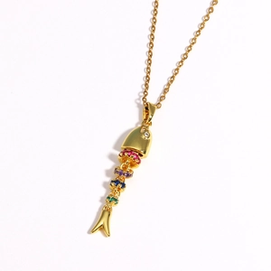 Macro shot of flexible multi-color gemstone fish pendant on a gold chain necklace