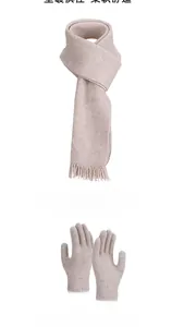 Detail of beige knitted scarf with tassels and touchscreen gloves for winter warmth