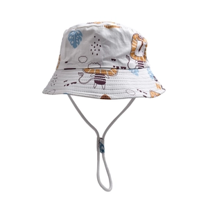 Detail of white cotton bucket hat with lion print and adjustable chin strap for kids