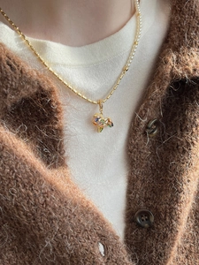 Close-up of gold-plated necklace featuring a colorful zircon pony pendant on a model