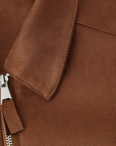 Détail de veste marron en suédine avec col à revers et fermeture éclair en métal