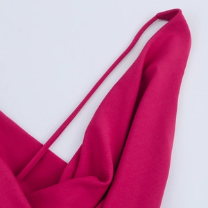 Dettaglio dell'abito in raso magenta con spallina sottile e scollo a cappuccio morbido