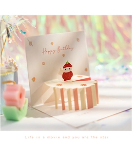 Detail of 3D pop-up birthday card featuring a strawberry cake design and golden text