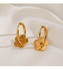 Détail de boucles d'oreilles fleurs en acier inoxydable doré 18K sur soie blanche