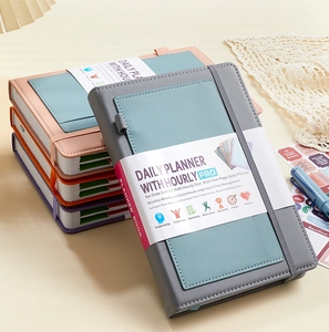 Detail of colorful faux leather planners with elastic bands and hourly daily layout pages