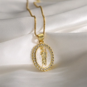 Detail of gold oval priest pendant with white inlay and crystals on silk fabric