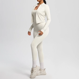 Detail of three-piece fitness set with zip jacket, tank top and leggings in cream color