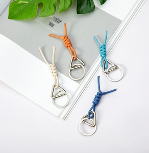 Flat lay of woven rope keychains in four colors with stylish metal hardware accents