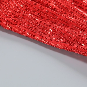 Close-up of vibrant red sequins on an elegant evening gown, showing fabric detail