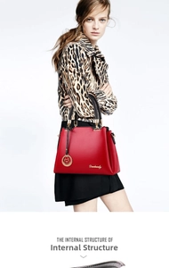Detail of red litchi texture handbag with gold hardware and logo on leopard coat