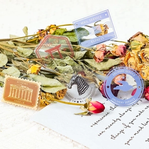 Flat lay of vintage travel postage stamp stickers with dried flowers on old letters