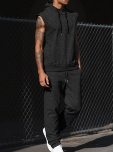 Detail of black hooded sleeveless sweatshirt showing dark textured knit fabric and drawstrings