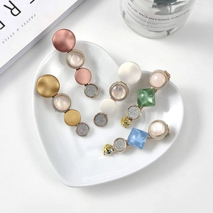 Set of four stylish acetate hair clips with marble patterns and glitter on a white heart tray