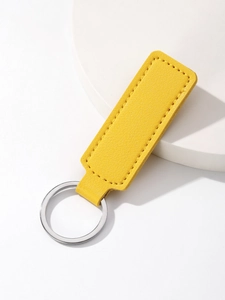 Detail of yellow lychee texture PU leather keychain with silver metal ring on white stand