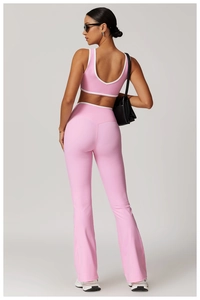 Rear view of pink cross-back sports top and high-waisted flared yoga pants with white trim