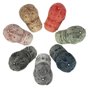 Flat lay of distressed washed denim baseball caps in seven assorted vintage colors