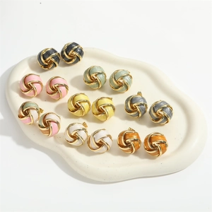Colorful woven sphere earrings in French vintage style on a ceramic jewelry tray