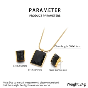 Detailed view of the square black glass pendant and earrings set on a gold snake chain