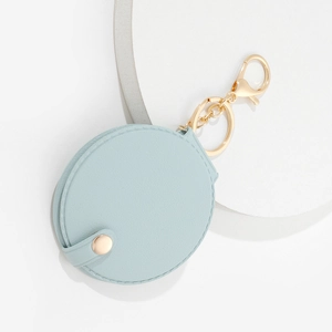 Detail of round light blue PU leather mini makeup mirror with gold keychain clasp