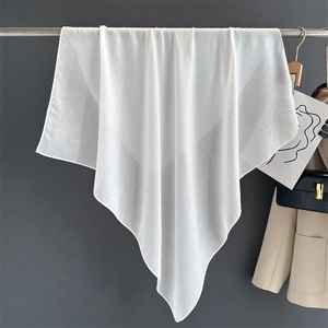 Detailed texture of white cotton linen square scarf hanging on a metal rod