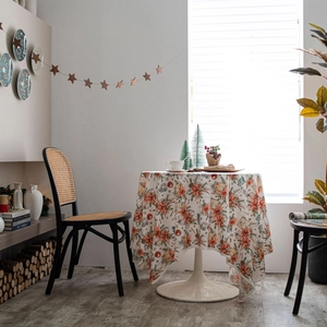 Christmas velvet tablecloth with poinsettia and gift prints on a white round table