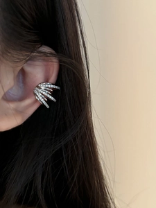 Detail of silver multi-layer ear cuff with zircons worn on a model's ear