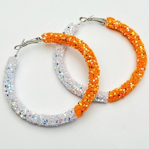 Detail of large hoop earrings with white and orange iridescent sequins in dual-color design