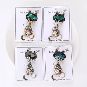 Detailed macro view of crystal cat brooches in four elegant color combinations