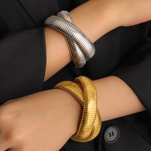 Gold and silver flexible spring snake bracelets with spiral texture on black suit sleeve