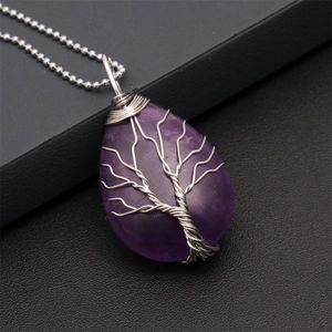 Close-up of silver wire-wrapped purple crystal teardrop tree of life pendant necklace
