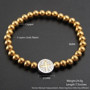 18K gold plated beaded bracelet with religious coin pendant on a matte black background