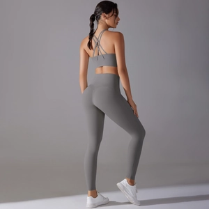 Detail of grey yoga set featuring backless cross-strap bra and high-waisted leggings