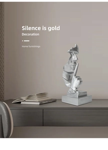 Macro detail of the silver Silence is Gold sculpture with its stable rectangular base