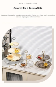 Detail of tiered cupcake stands with petal edges, gold handles and cream glass plates