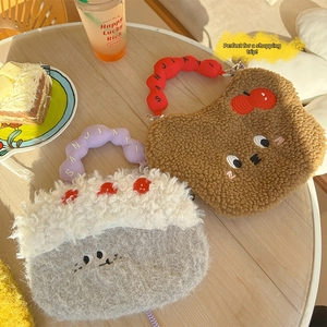 Close-up of cute cartoon plush handbags with embroidery on a cozy wooden cafe table