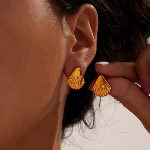 French shell-shaped gold earrings with diamonds and pearls worn by a model