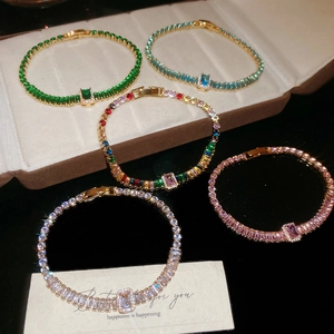 Primo piano di eleganti bracciali tennis con zirconi rettangolari colorati placcati oro