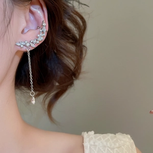 Detail of silver tassel ear cuff with sparkling teardrop crystals on model's ear