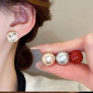 Square crystal earring and multiple colored pearl studs shown on model for women