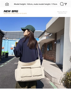 Outdoor shot of a cream-colored canvas messenger bag with large front pockets and wide strap