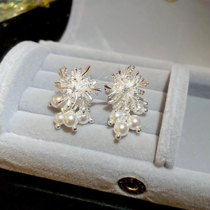 Macro shot of silver flower earrings with white pearls and zircons in a gray jewelry box