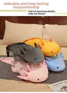 Close-up of colorful plush axolotl stuffed animals in pink, blue, and yellow stacked on bed