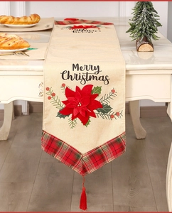Macro view of Christmas table runner with Poinsettia embroidery and plaid fringe edge
