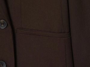 Detail of dark brown blazer pocket stitching and textured resin button closure