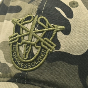 Detaillierte Makroaufnahme der Militär-Stickerei auf einer Camouflage-Baseballkappe