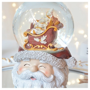 Macro shot of Santa Claus snow globe with a resin base and festive golden details